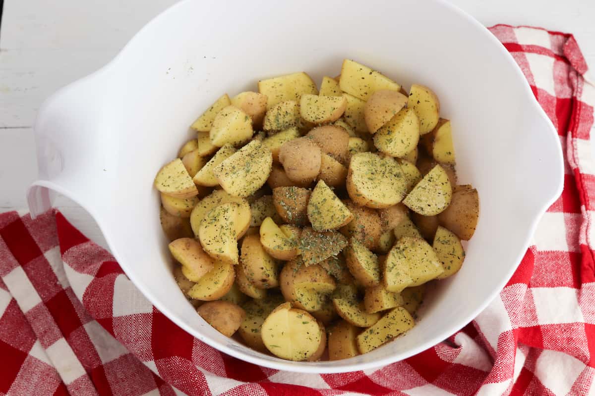 Roasted potatoes with seasoning in a bowl.