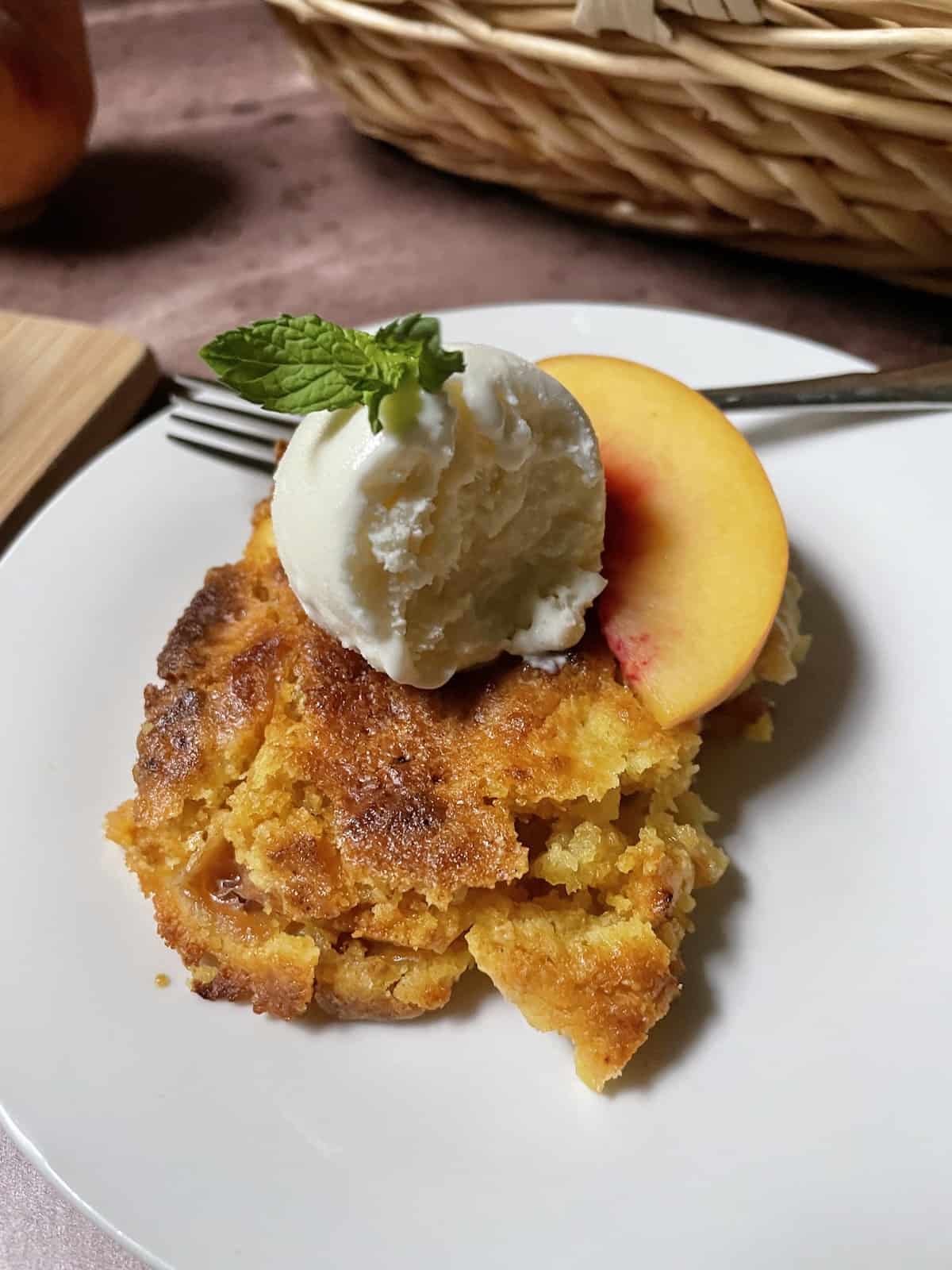 Peach cobbler with ice cream and a mint sprig.