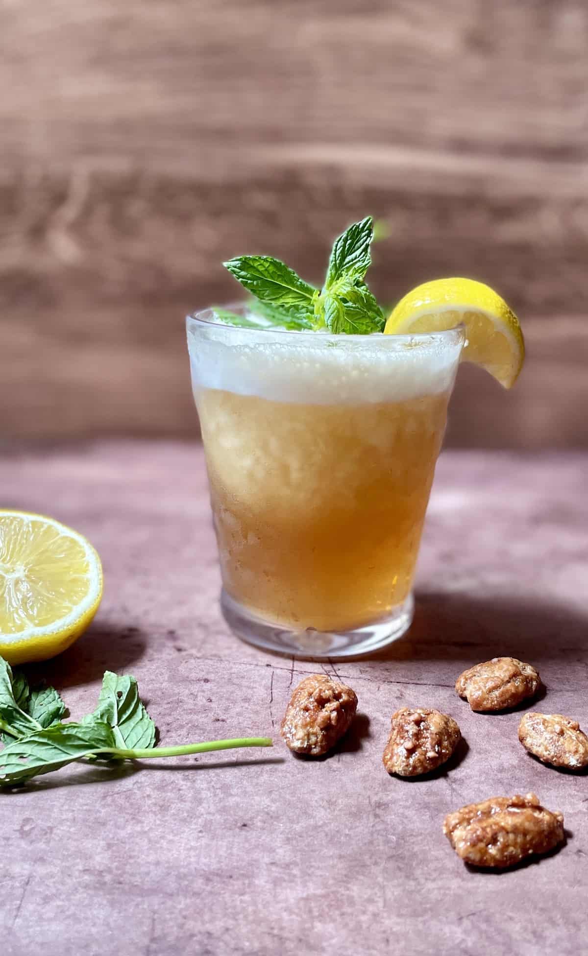 Whiskey slush in a glass with lemon and mint.
