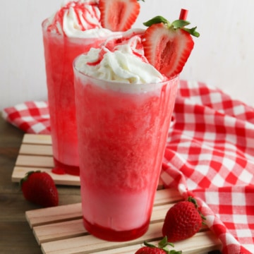 Strawberry soda with whipped cream and strawberry on top.