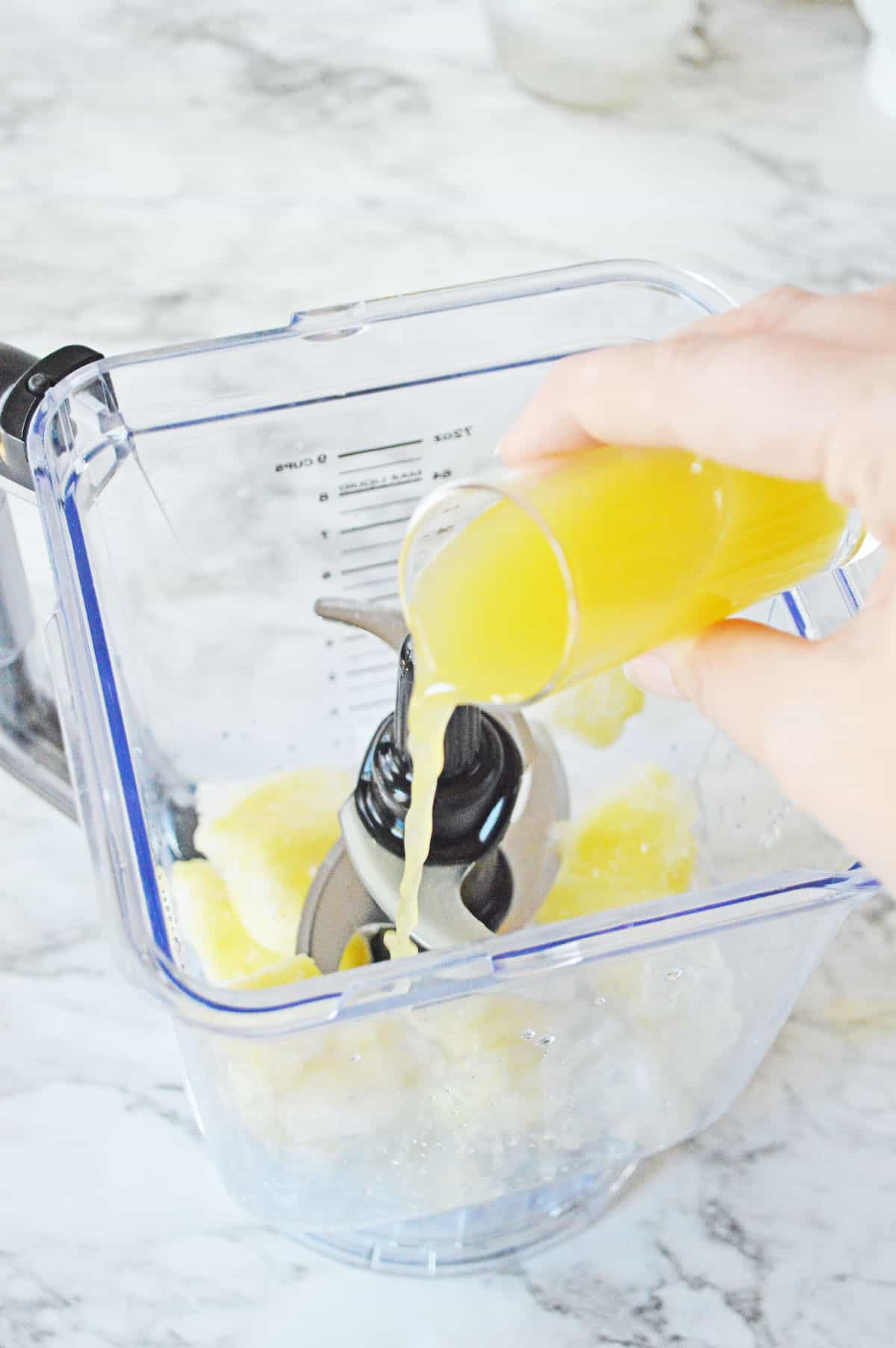 Adding pineapple juice to blender.