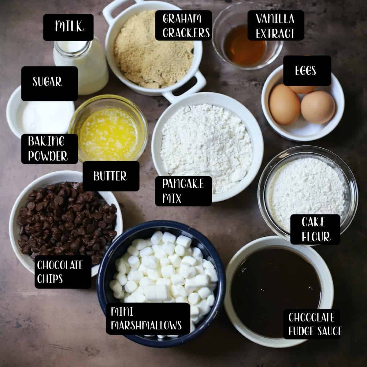 Ingredients to make smores cake on a brown table.