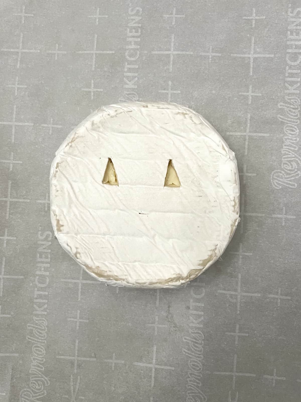 Brie with triangle eyes carved out.
