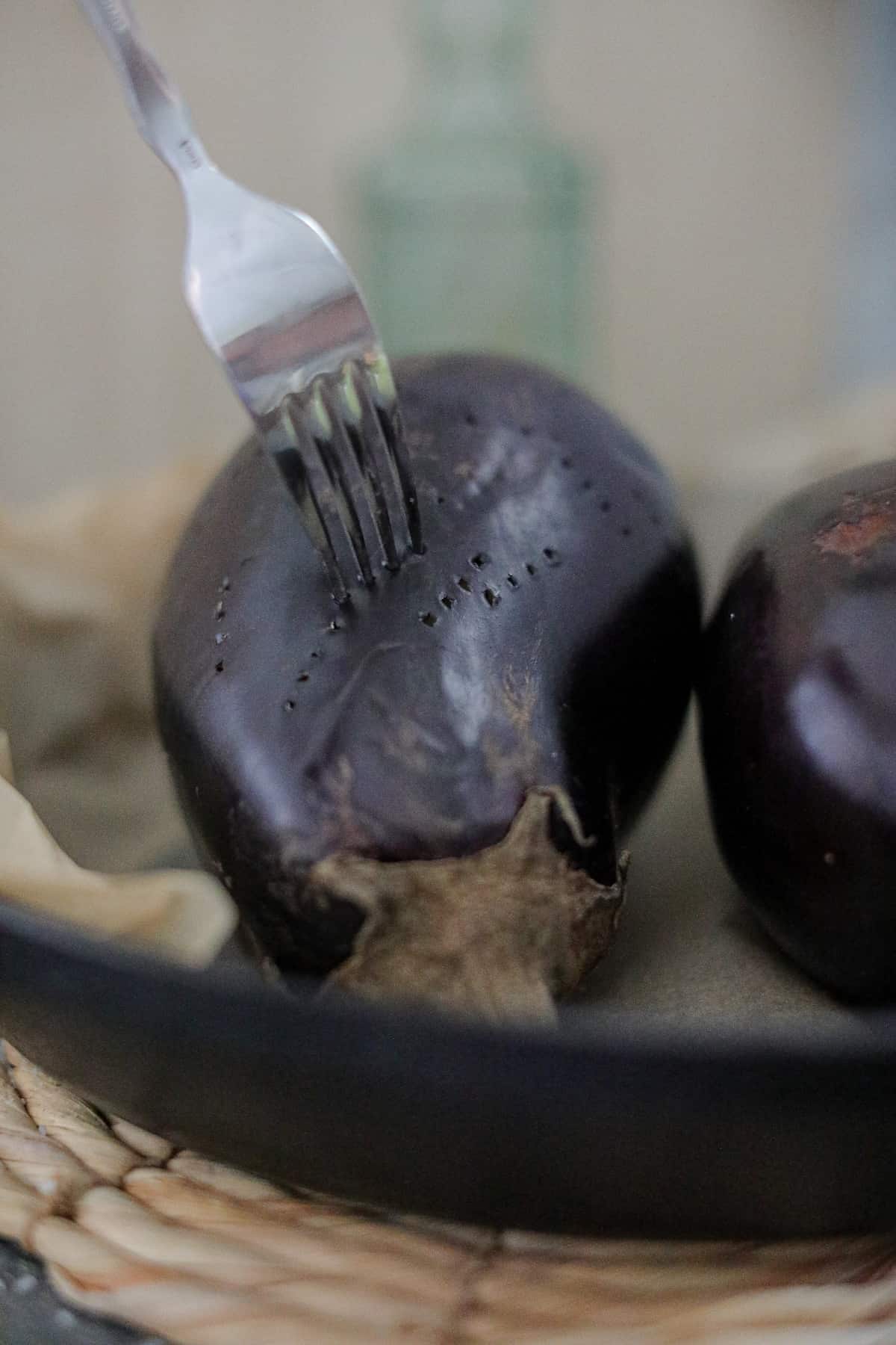 Eggplant being pierced with fork.