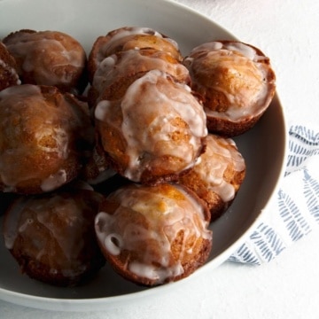 Apple fritters in a white bowl.