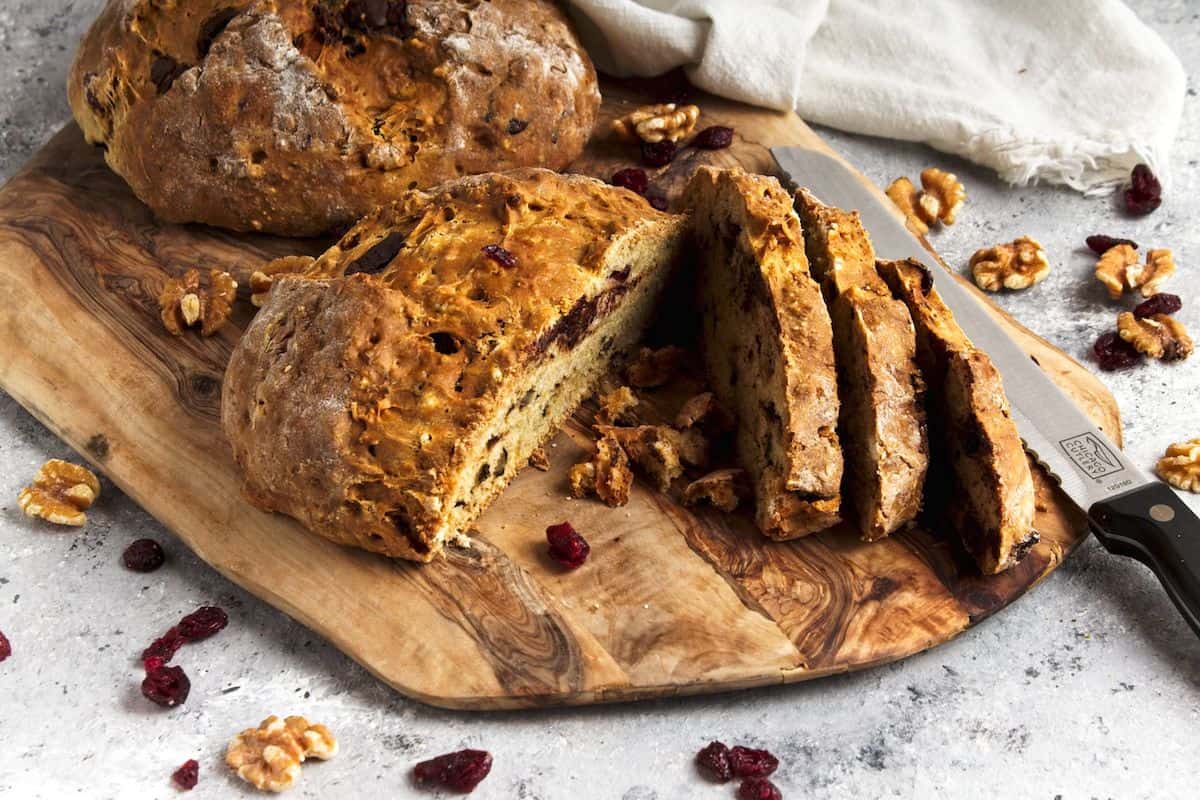 Two loaves of bread on cutting board.