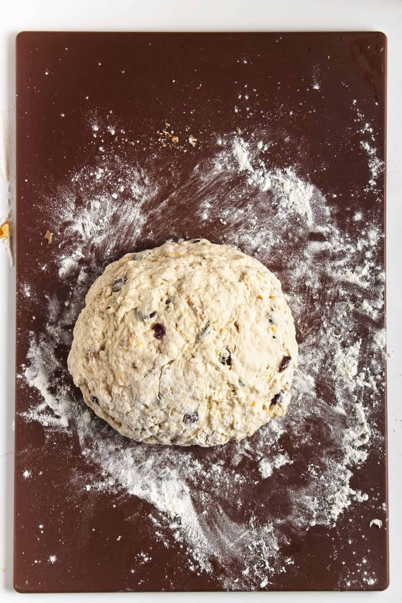 Dough formed into a loaf on floured mat.