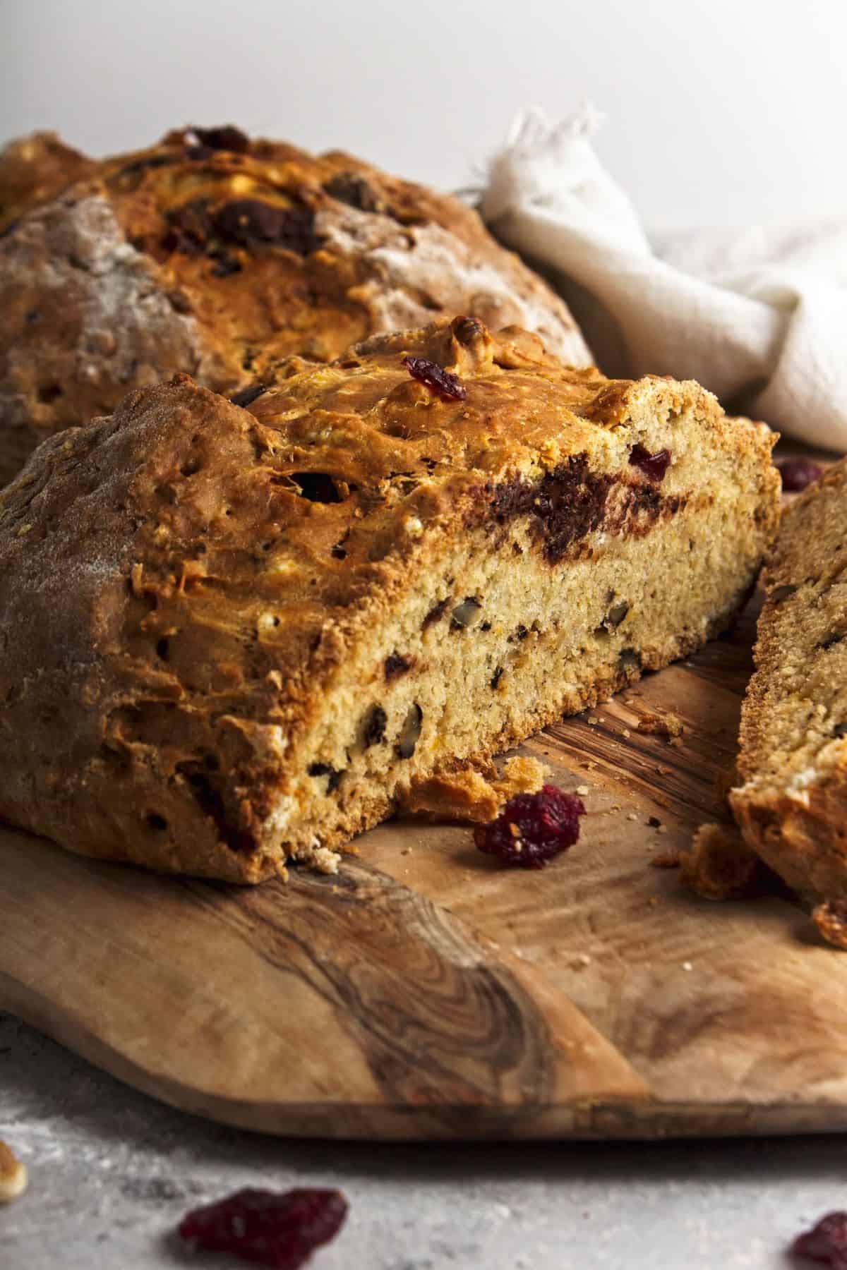 Loaf of bread on cutting board with slice.