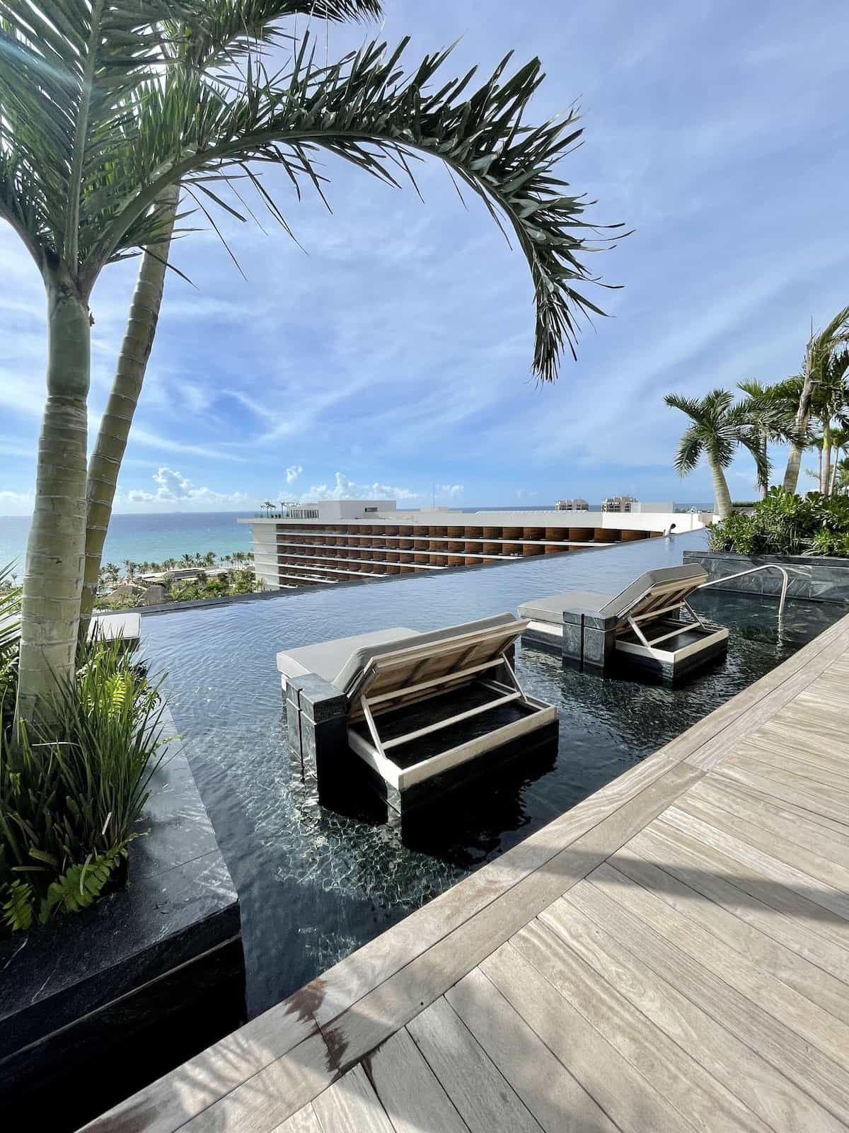 Lounge chairs on rooftop facing ocean.