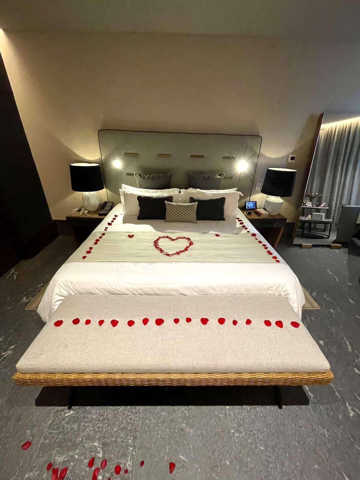 Bed with rose petals in a heart design.