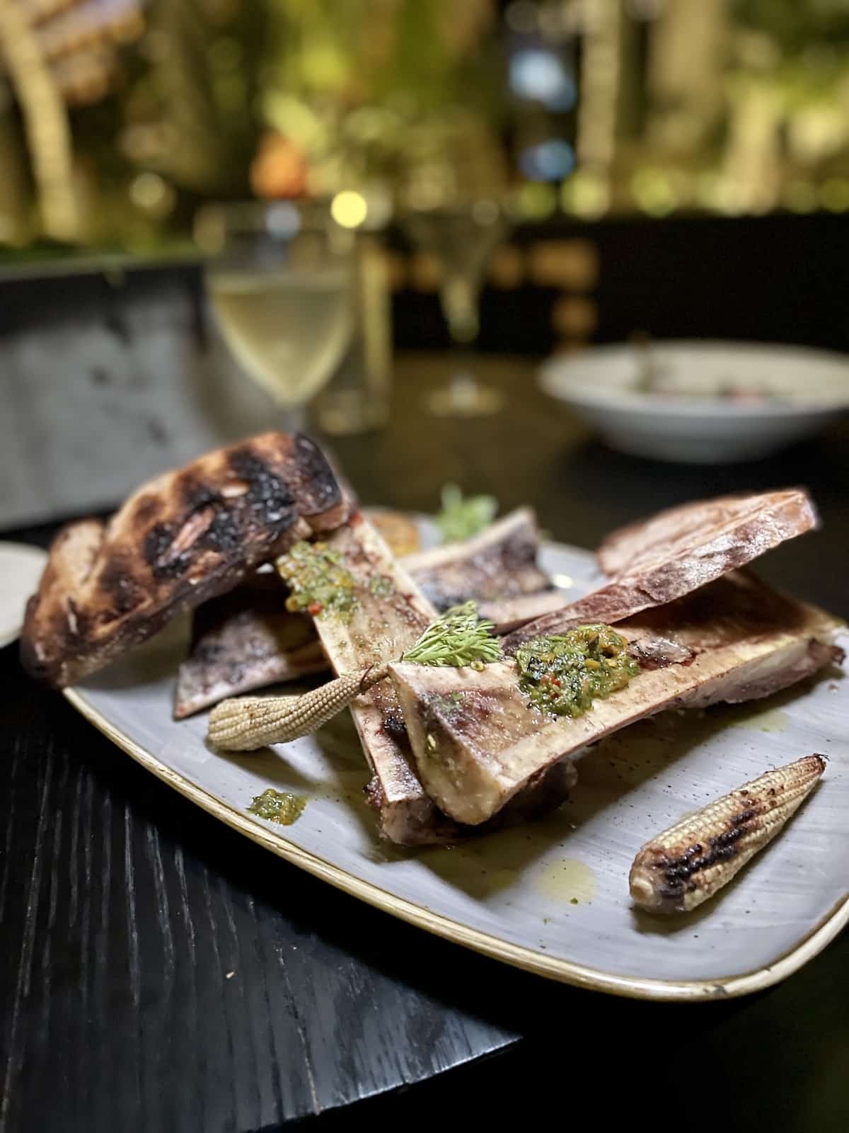 Plate with bone marrow, corn, and toasts.