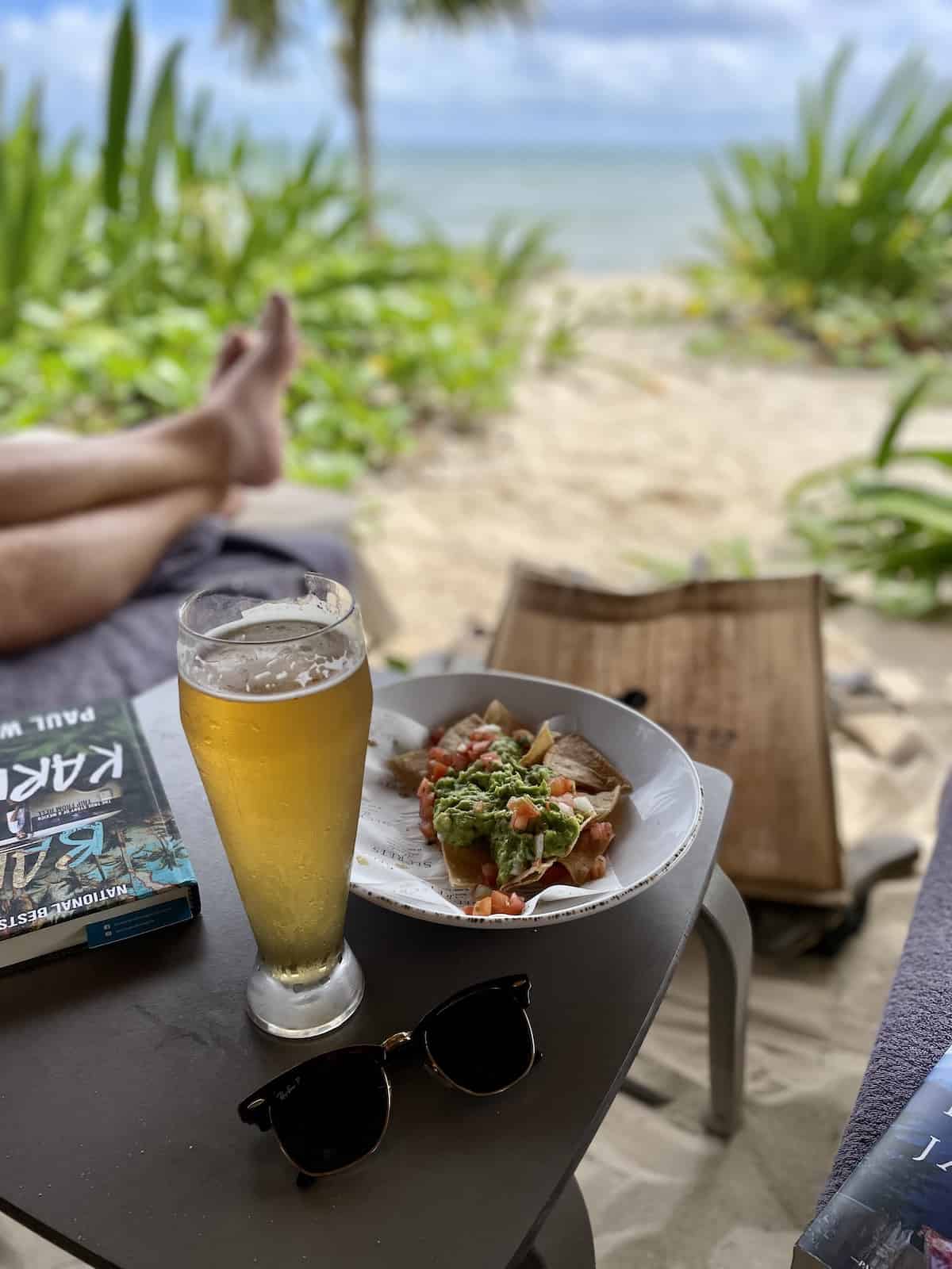 Nachos and beer on table at beach.
