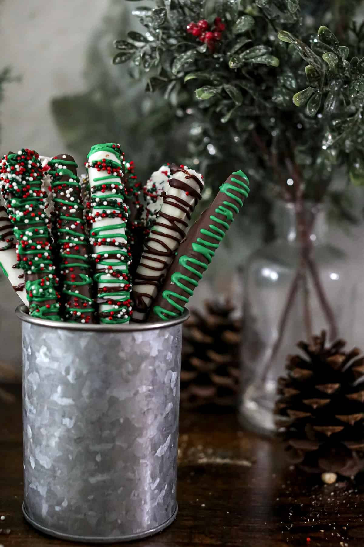 Holiday decorated chocolate covered pretzels in a silver coffee tin.