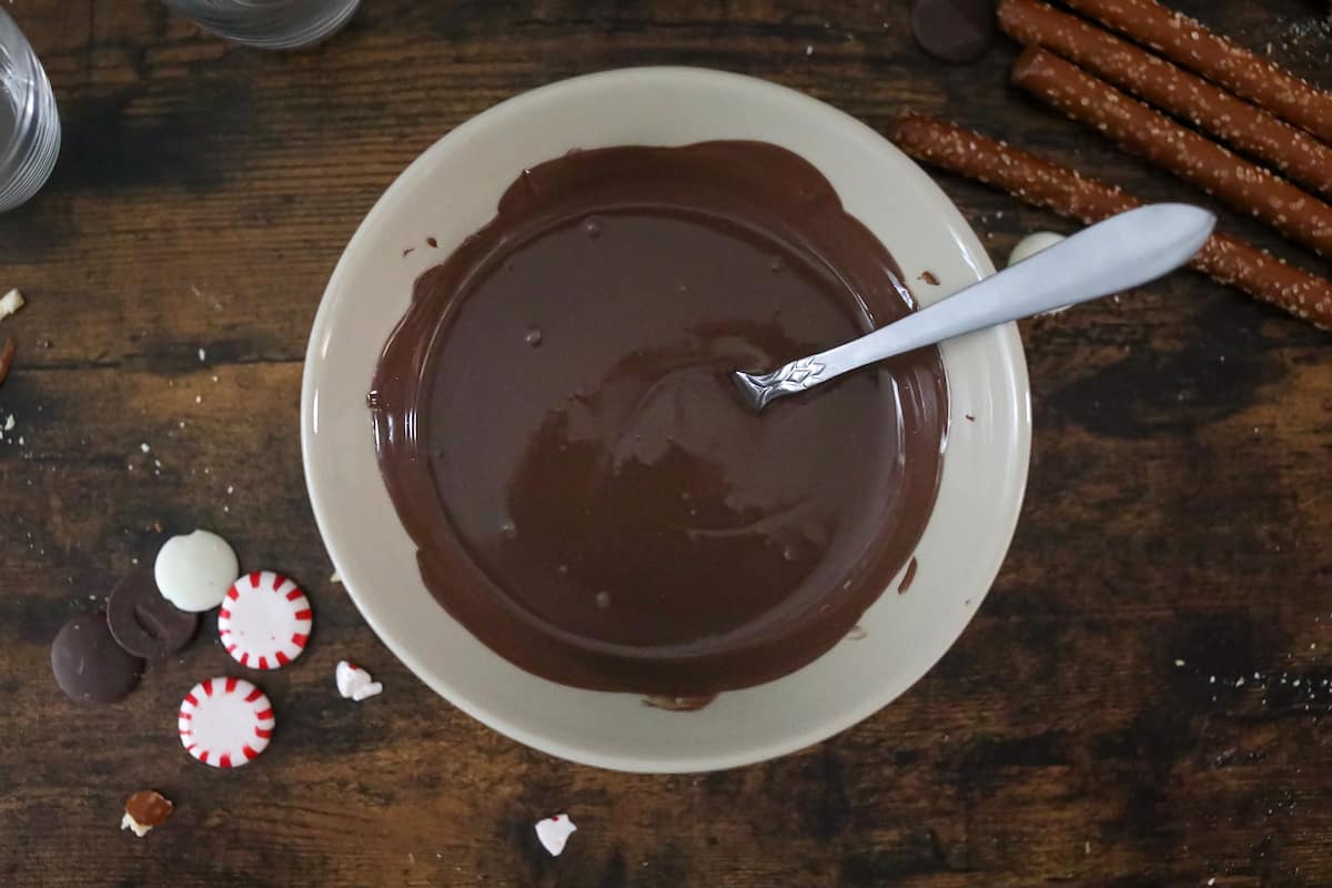 Bowl of melted chocolate on wood table.