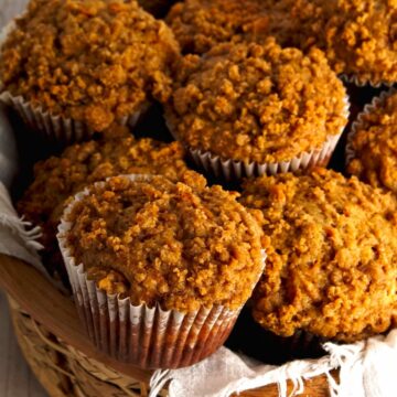 Sweet potato muffins in a basket on a white table.