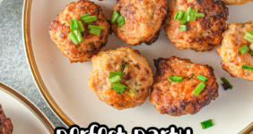 Chicken meatballs sprinkled with green onions on a white plate.
