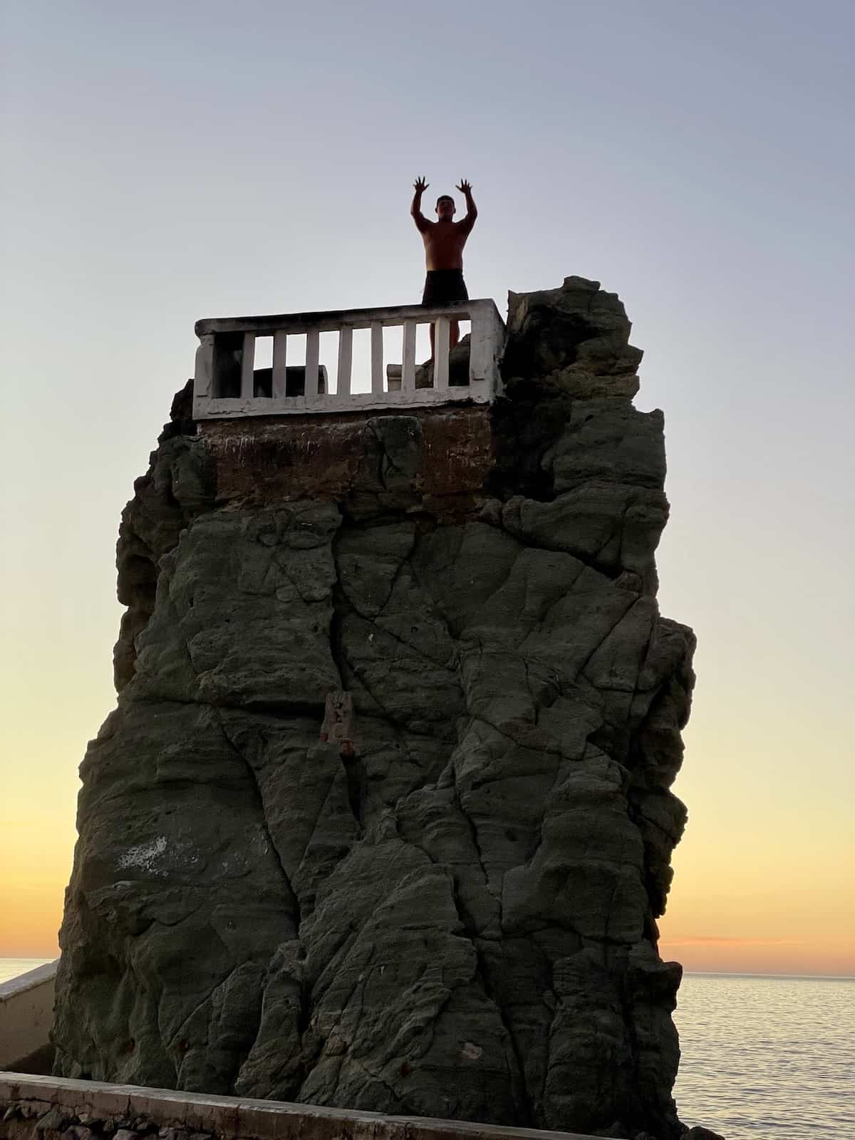 Cliff diver on platform.