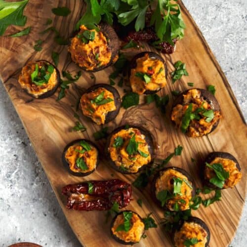 Stuffed mushrooms on a wood board.