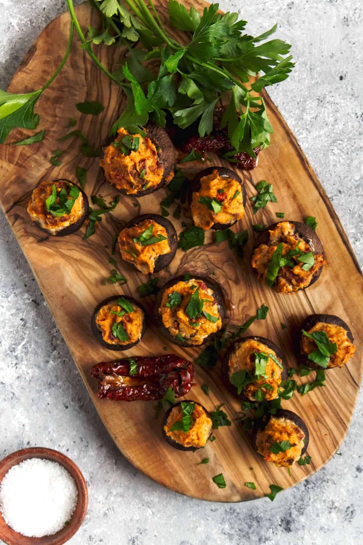 Stuffed mushrooms on a wood board.