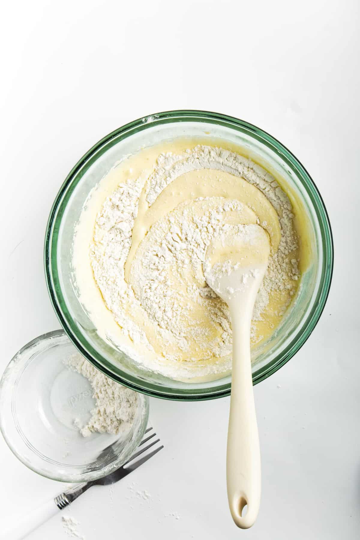 Batter for cookies in a glass bowl with wooden spoon.  