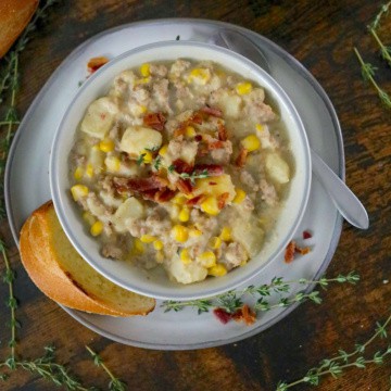 Corn chowder recipe with sausage in a bowl on a saucer.
