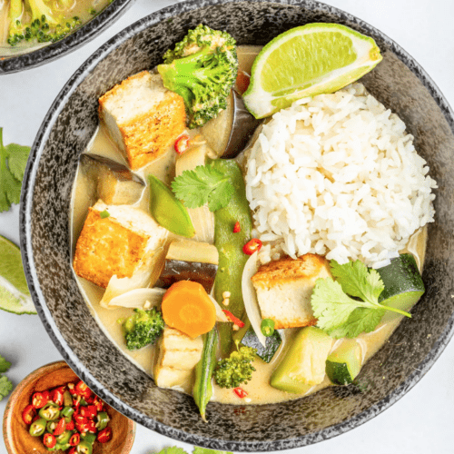 Thai green curry in a grey dish with lime.