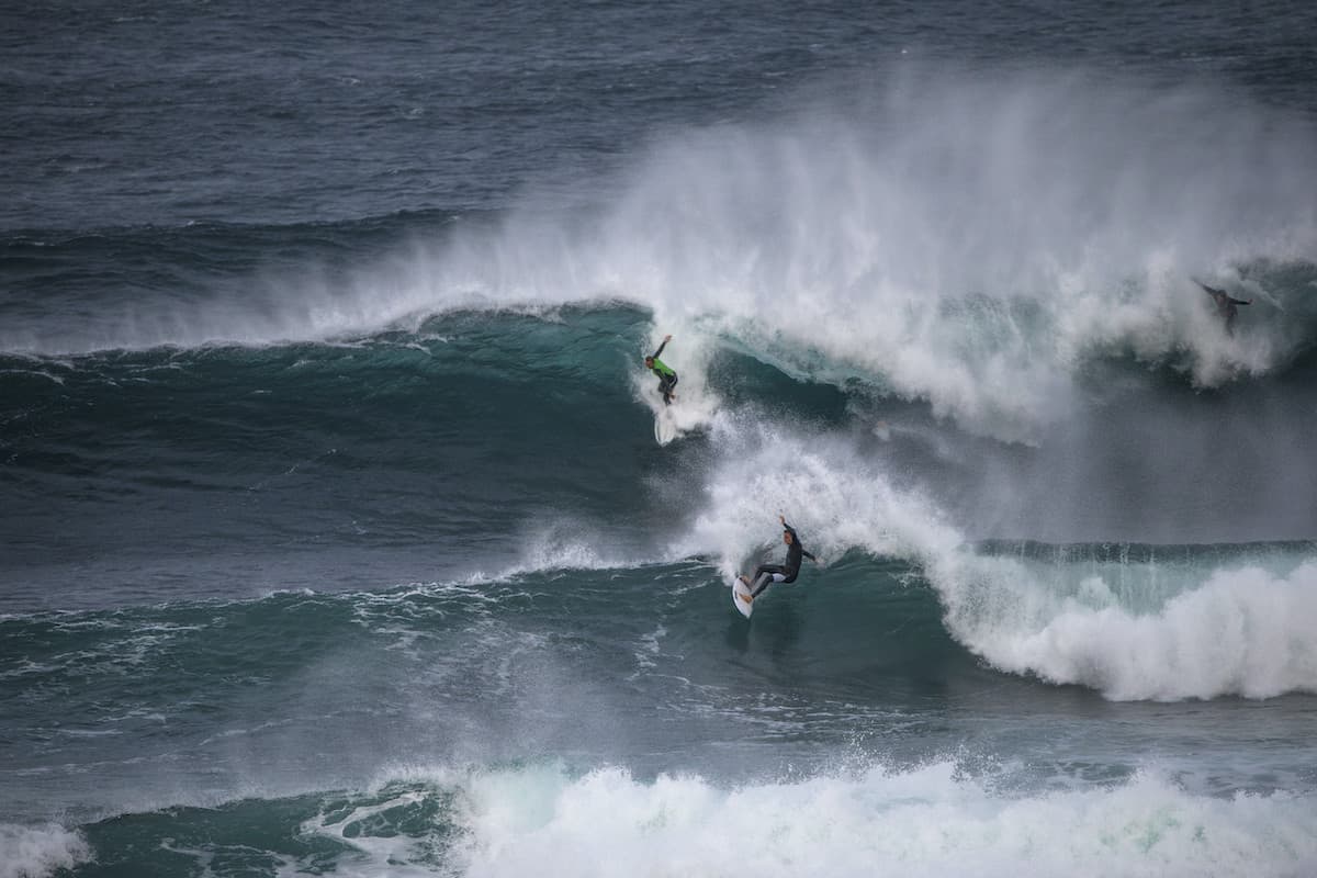 Two surfers catching waves.