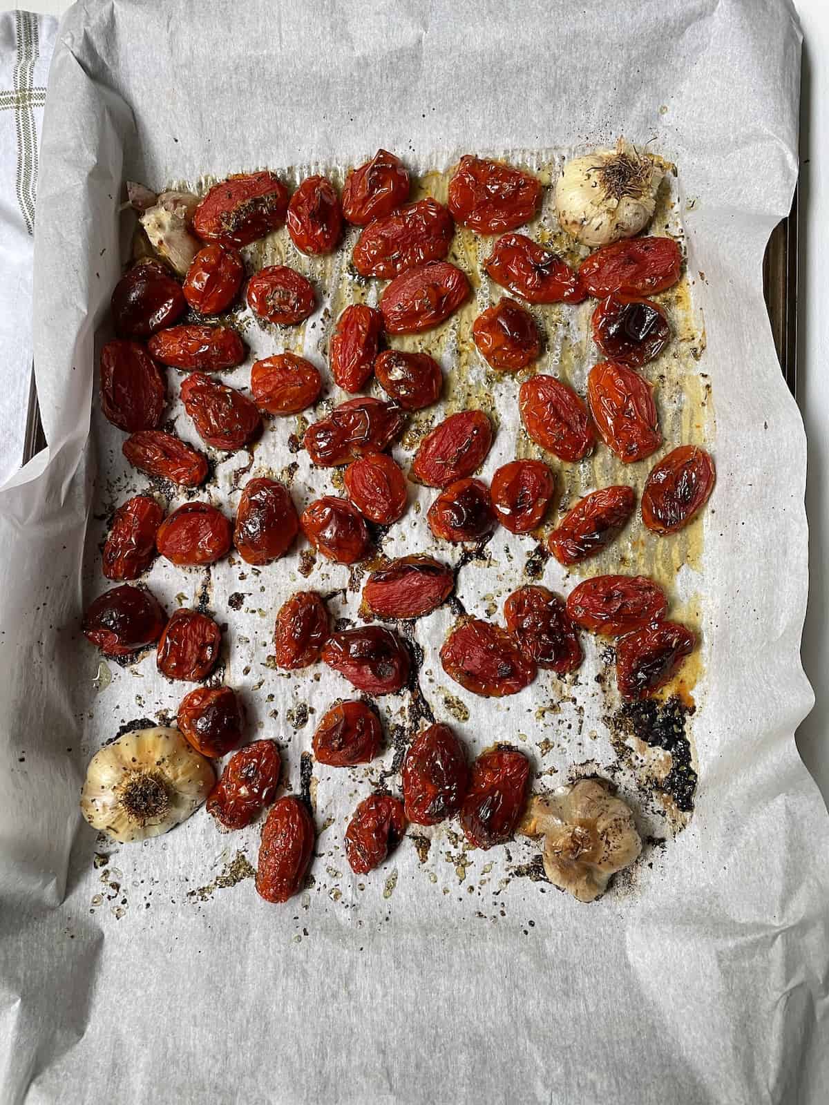 Grape tomatoes and garlic cooked on parchment.