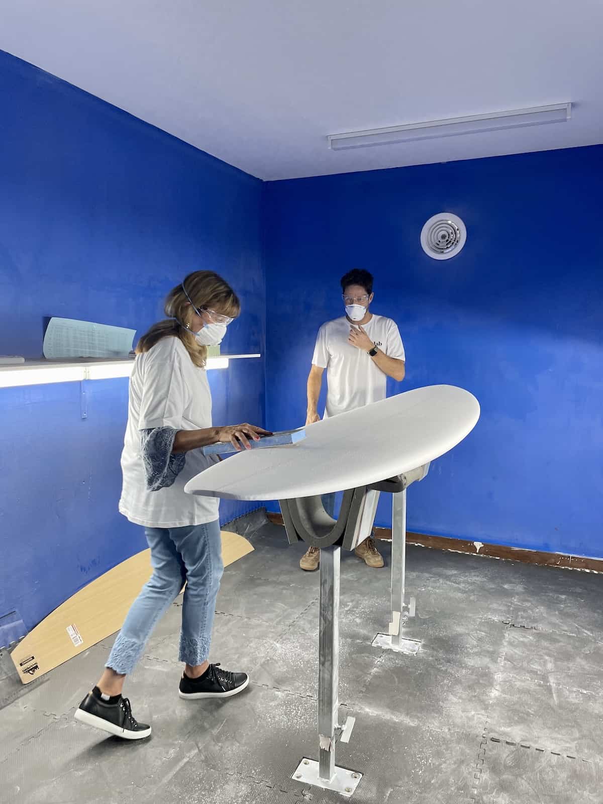 Man and woman making a surfboard.