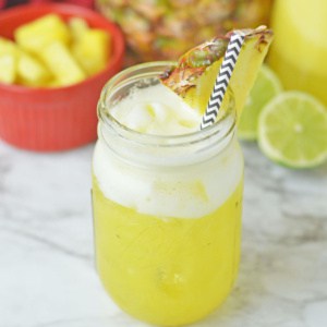 Pineapple water in a mason jar on a marble counter.