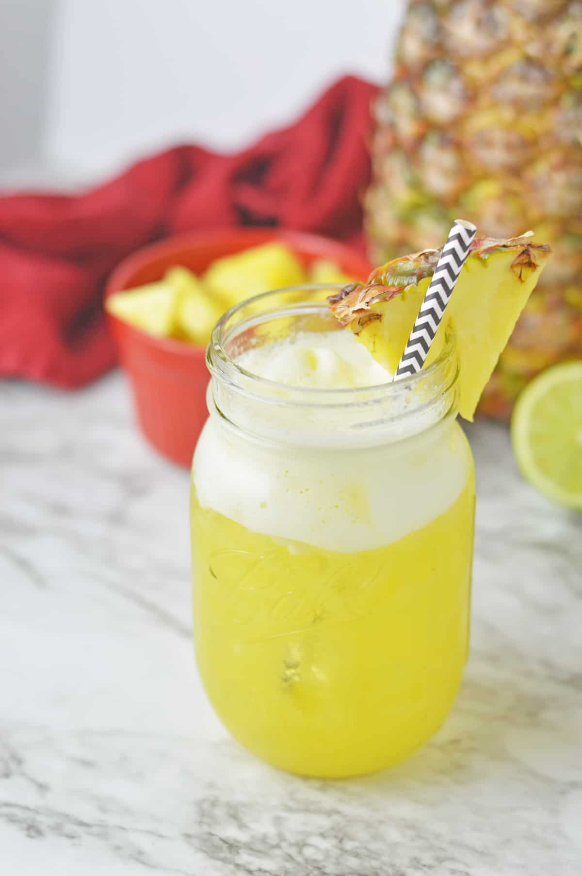 Pineapple water in a mason jar on a marble counter.