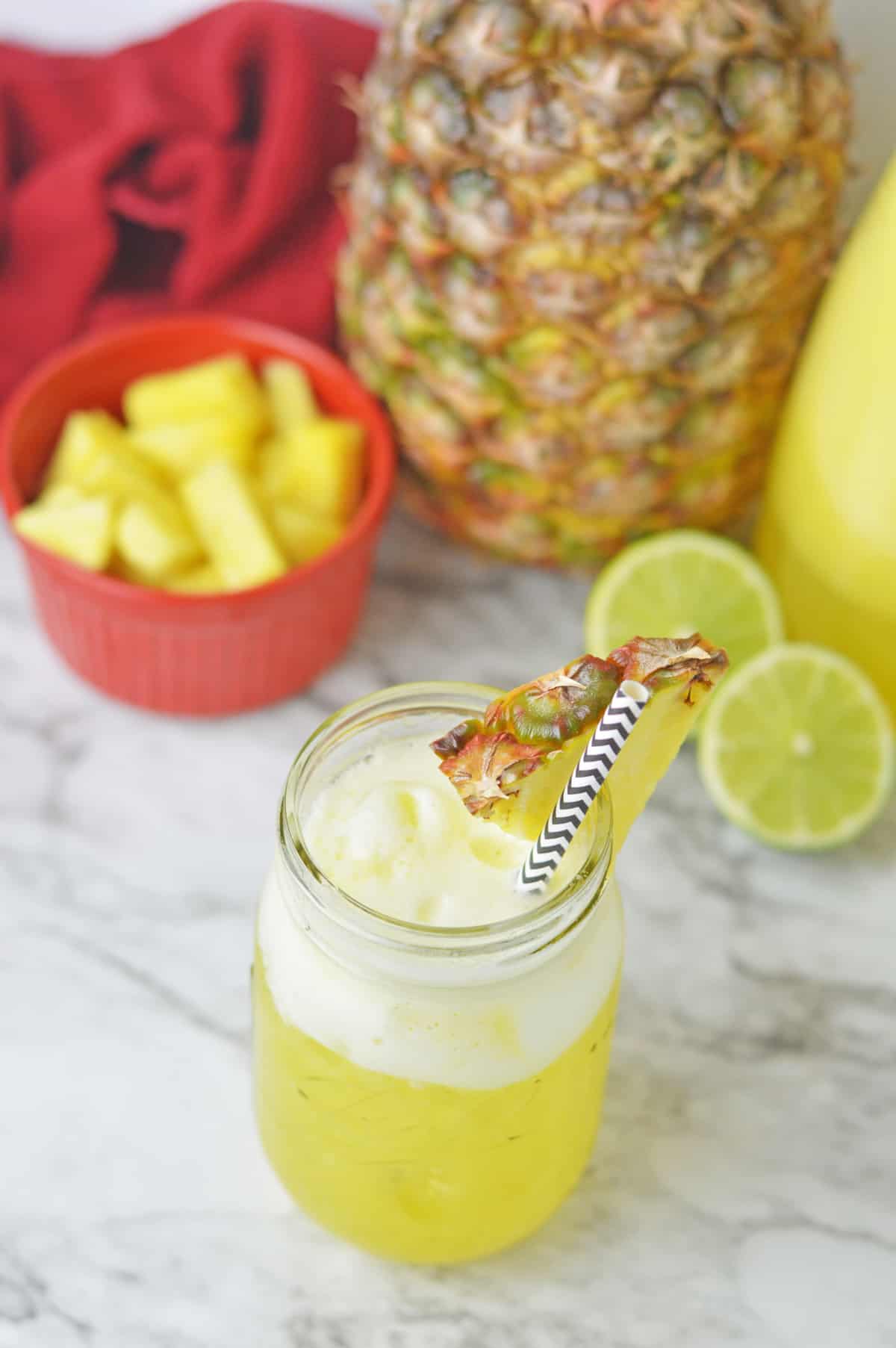 Pineapple water in a mason jar on a marble counter.