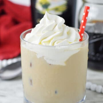 Baileys Iced Coffee in a glass with a red straw.