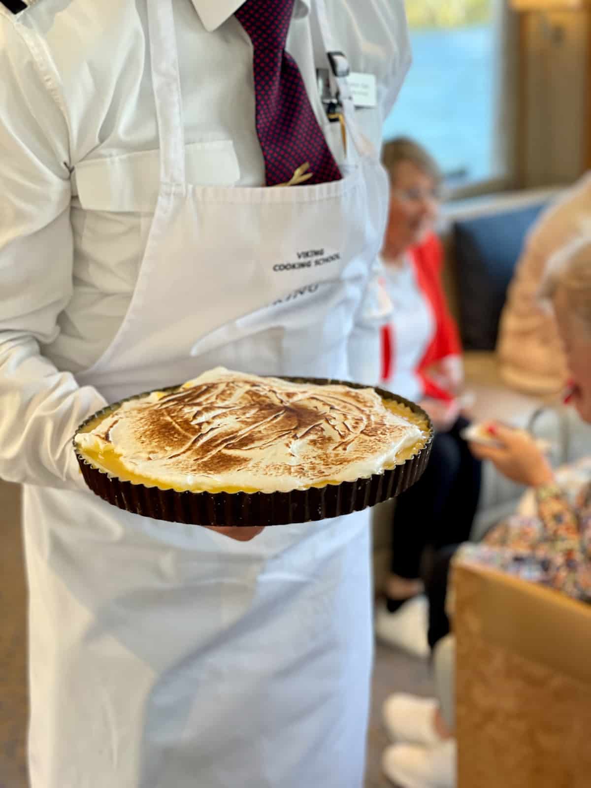 Chef holding a lemon meringue pie.
