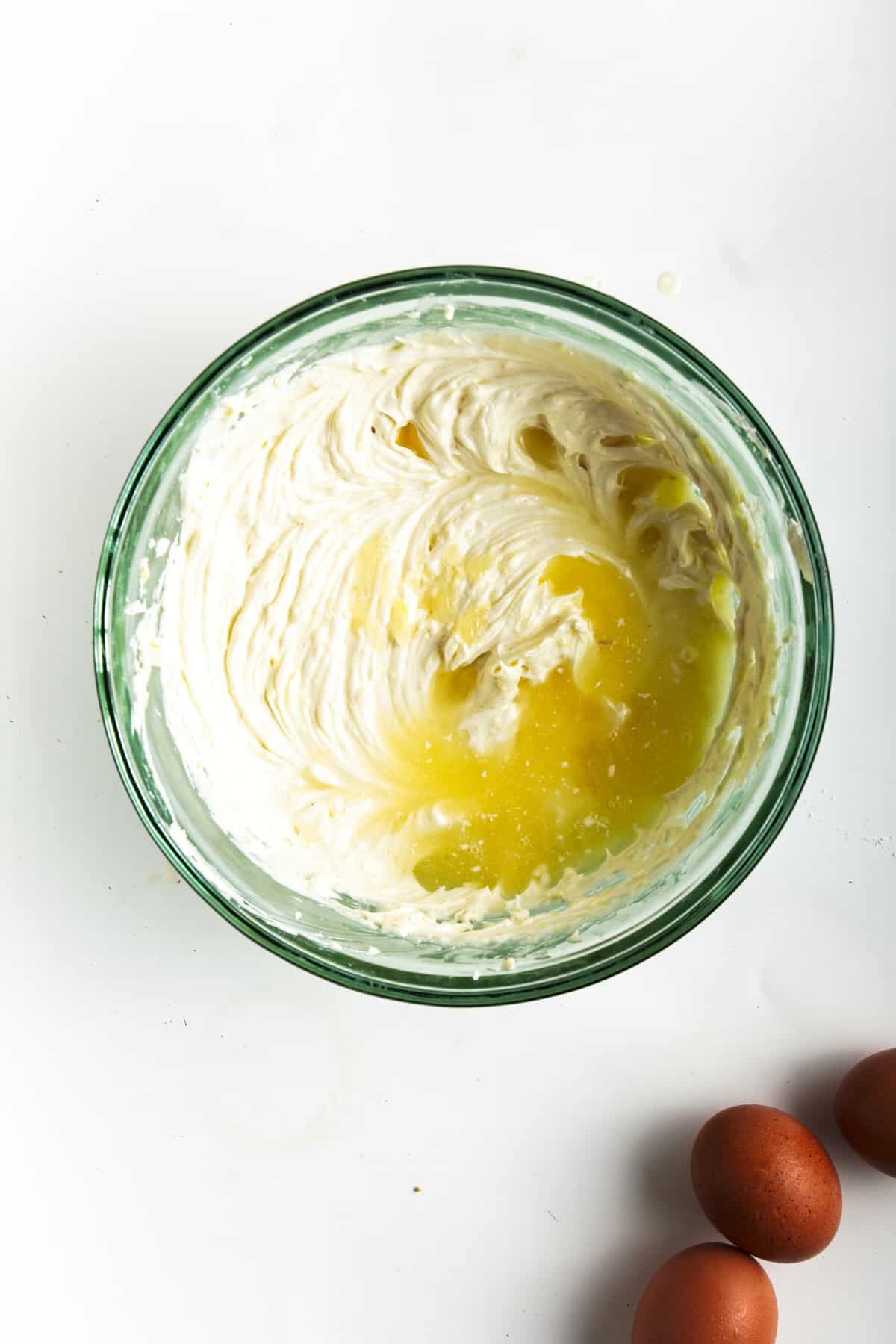 Cream cheese mixture with lemon juice in glass bowl.