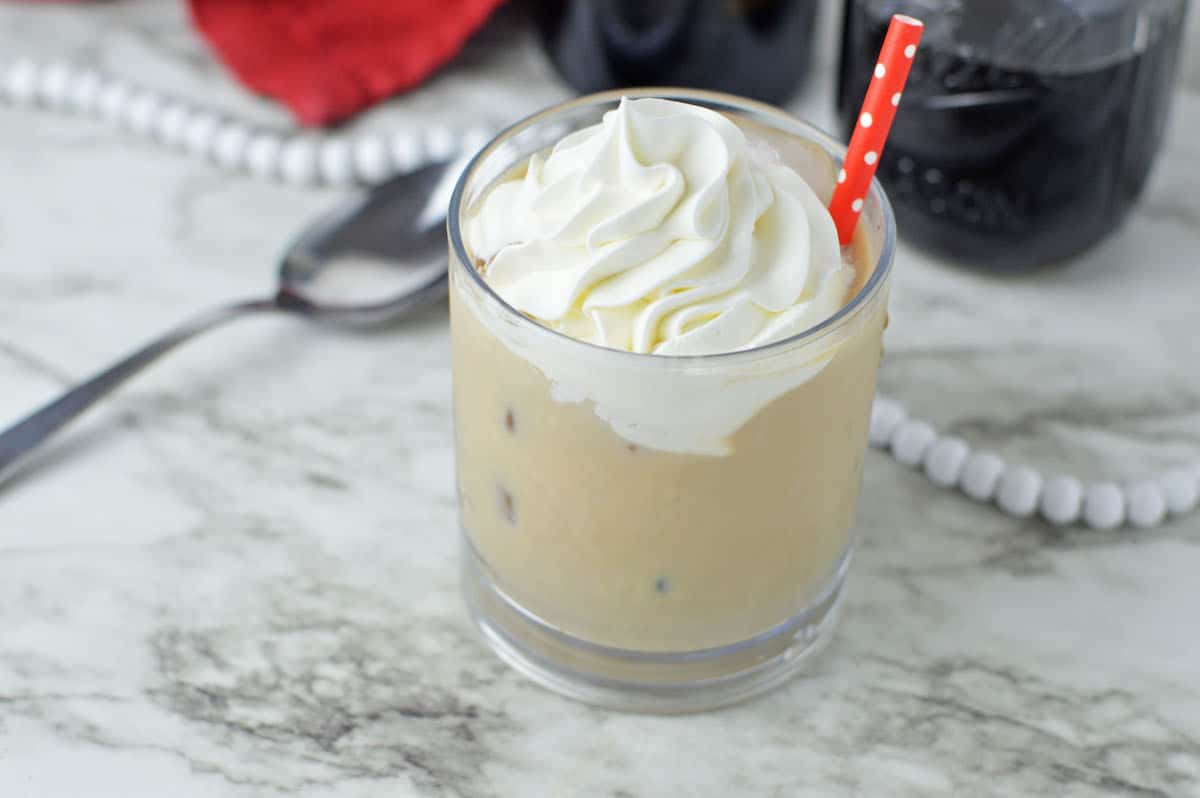 Baileys Iced Coffee in a glass with a red straw.