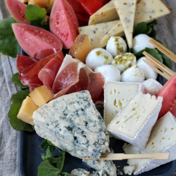 Cheese and fruit on a charcuterie board.