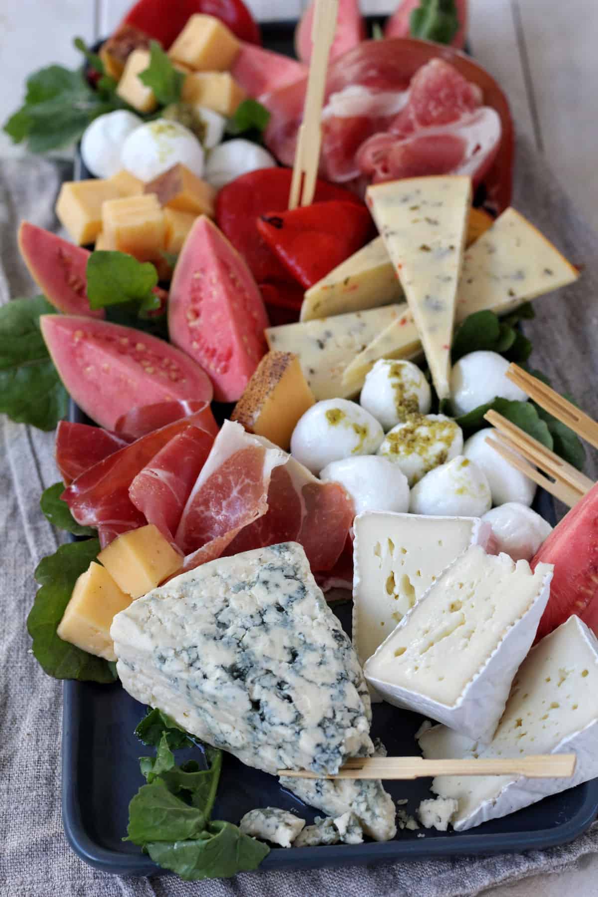 Charcuterie board of cheese, meats, and fruit.