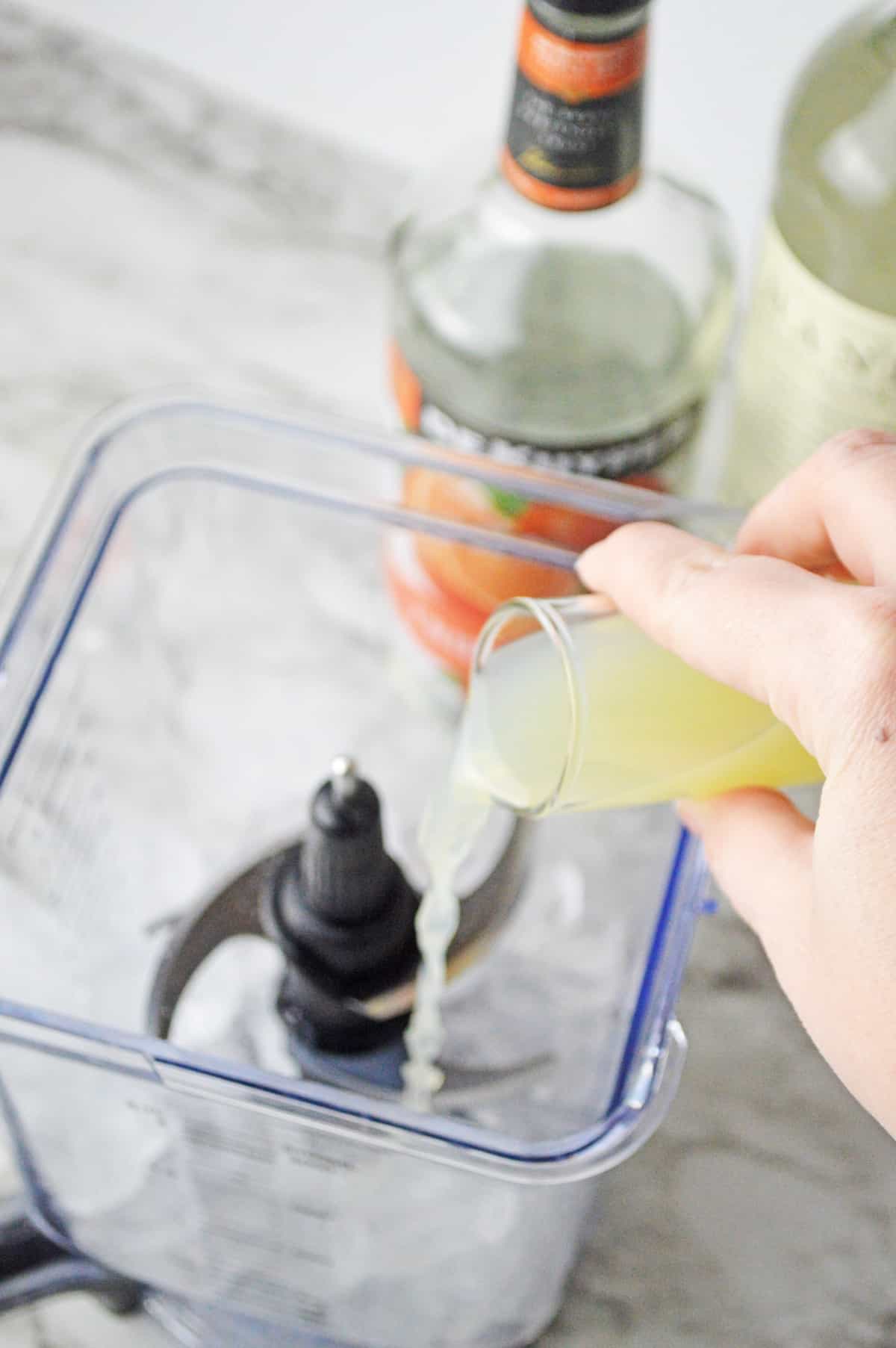 Lime juice being poured into a blender.