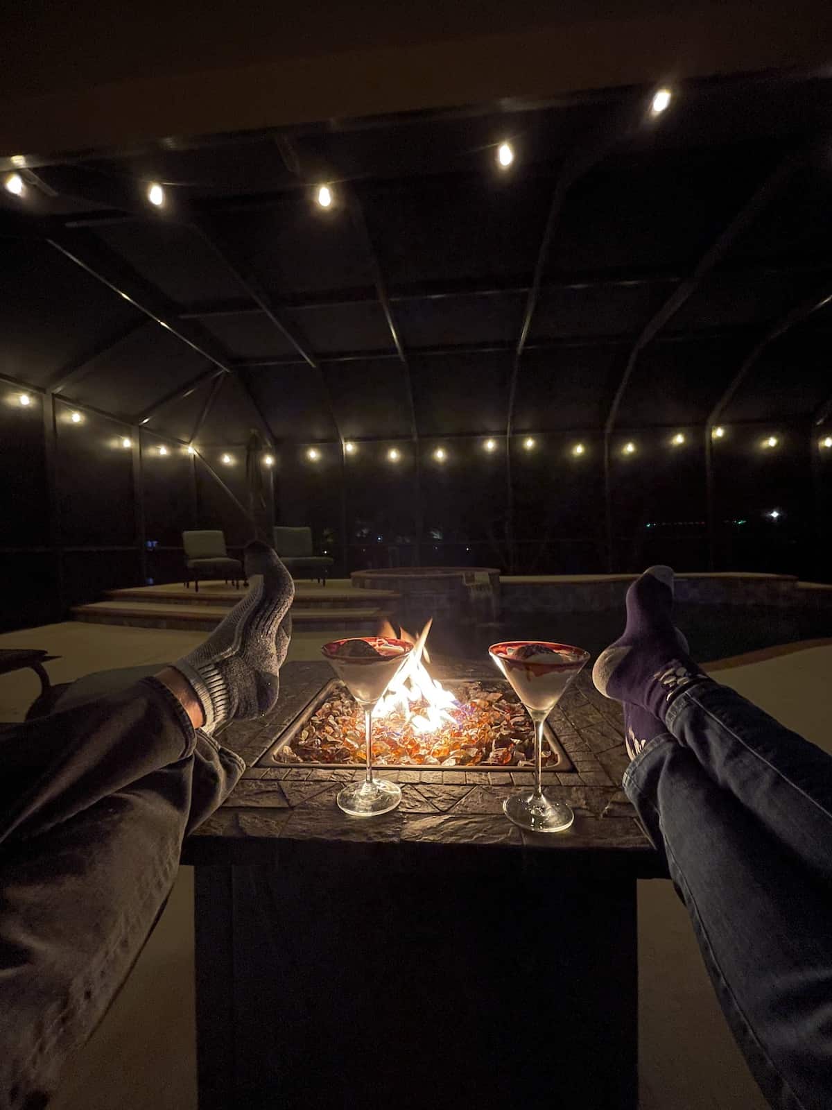 Feet up on fire pit with cocktails.