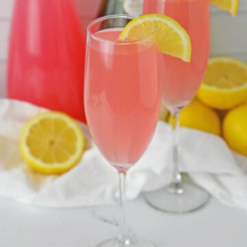 Pink Mimosa on a champagne flute with a lemon slice.