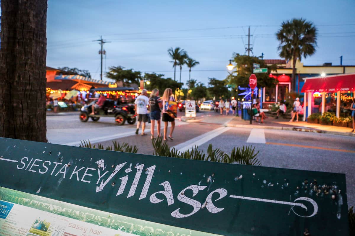 Siesta Key village street with people and cars.