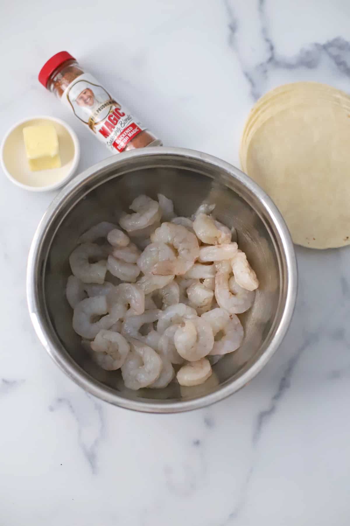 Raw shrimp in stainless bowl.