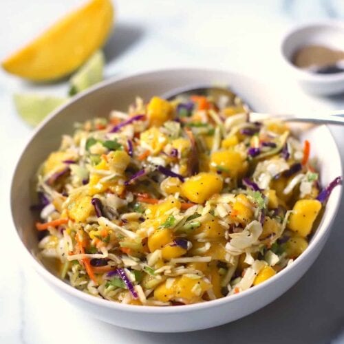 Mango slaw in white bowl on counter.