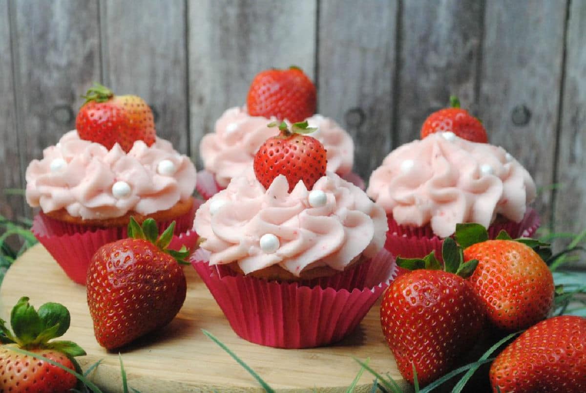Strawberry cupcakes on a wood board.