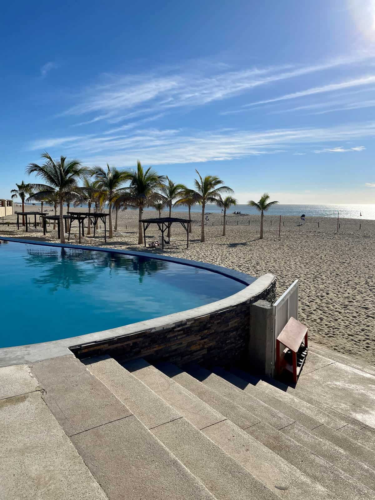 Pool with beach in background.