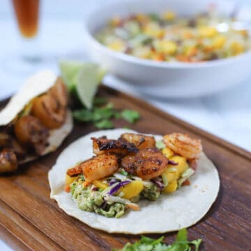 Grilled shrimp tacos on a wood board.