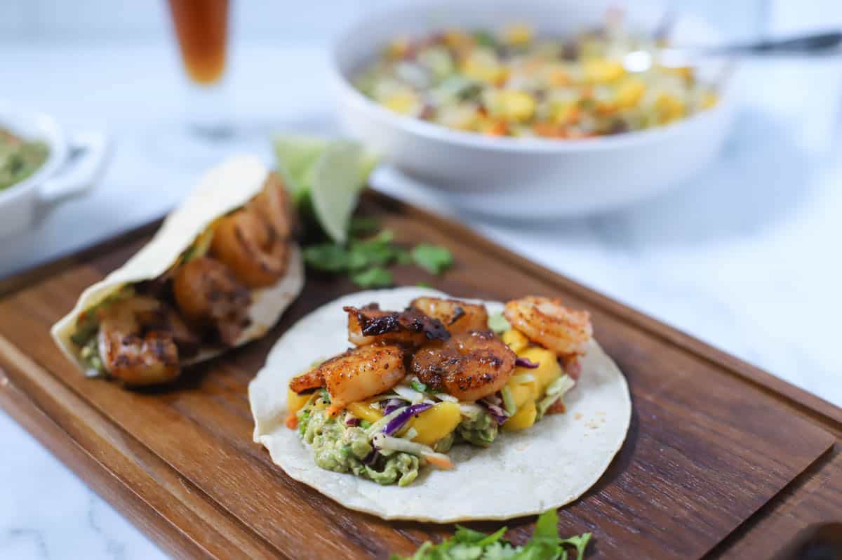 Grilled shrimp tacos on a wood board.