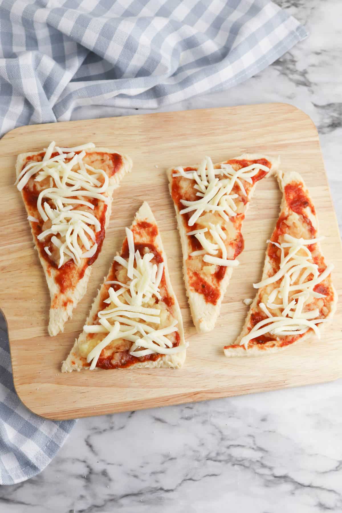 Crescent roll dough with pizza sauce, cheese, and pineapple