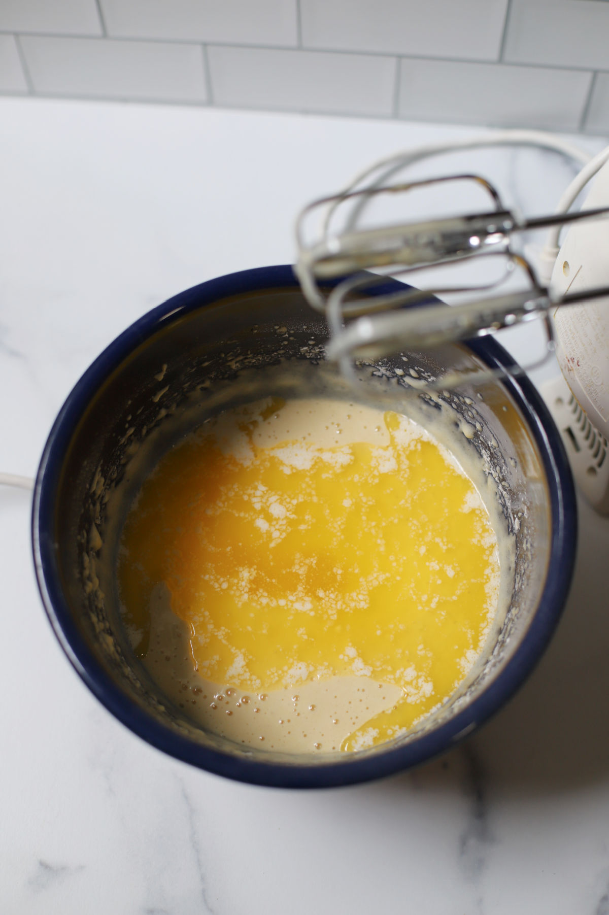 Batter for cake with melted butter on top.